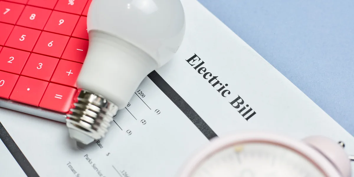 Calculator, lightbulb and an electricity bill on a desk